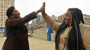 Mykidra "Nyki" RObinson shares a high five with supporter Tiffany Simpson.