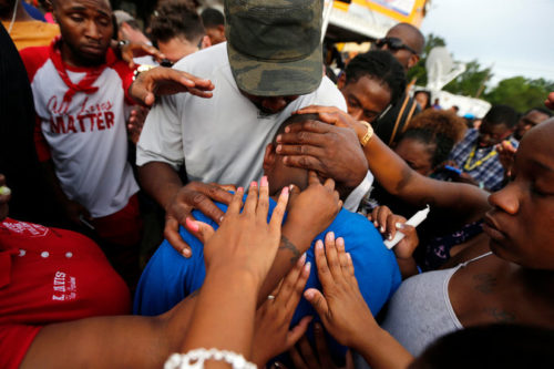 Cameron Sterling being comforted at a vigil near where his father, Alton, was killed by the police in Baton Rouge, La., last week. Credit Gerald Herbert/Associated Press