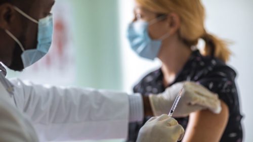 _115623880_yellow white woman gets vaccinated