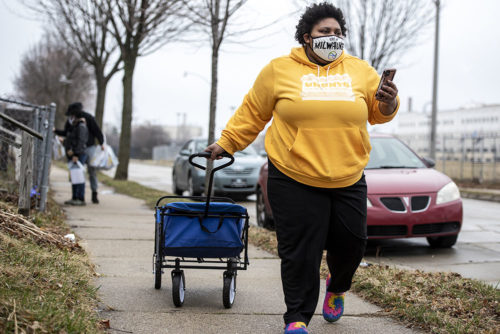 Melody McCurtis, a deputy director at Metcalfe Park Community Bridges, pulls a container filled with COVID-19 vaccine information for Milwaukee residents on March 27, 2021. Her group worked with the city health department and Milwaukee nonprofits to launch vaccination clinics open to residents 16 and older who live in Milwaukee’s Metcalfe Park and Amani neighborhoods. “We're seeing the effects of what access, real outreach and commitment does to a community that has been oppressed and almost left on the back burner for almost a year now,” McCurtis says.  (Angela Major/WPR)