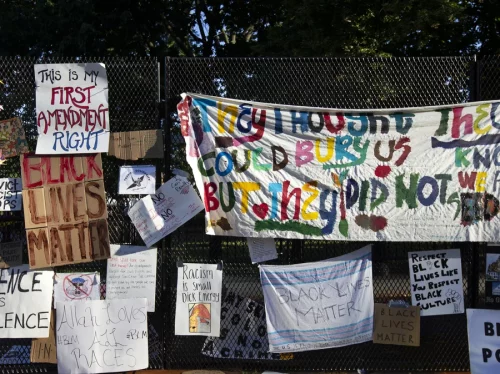 Signs are hung on a fence at Lafayette Square near the White House, during ongoing protests against police brutality and racism in June 2020. 
JOSE LUIS MAGANA/AFP via Getty Images