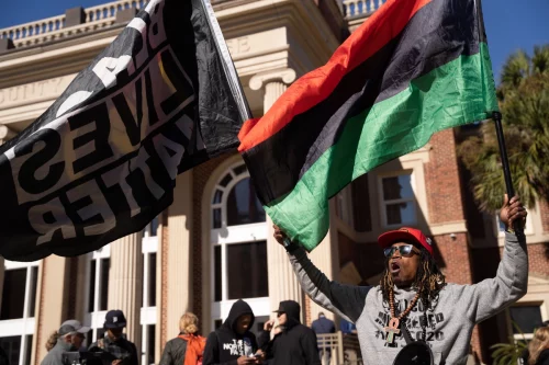 Activist Michael Harris demonstrates outside of the Glynn County Courthouse on November 23, 2021, during jury deliberations in the trial of the killers of Ahmaud Arbery. Greg McMichael, his son Travis McMichael, and a neighbor, William “Roddie” Bryan were found guilty. (Photo by Sean Rayford/Getty Images)