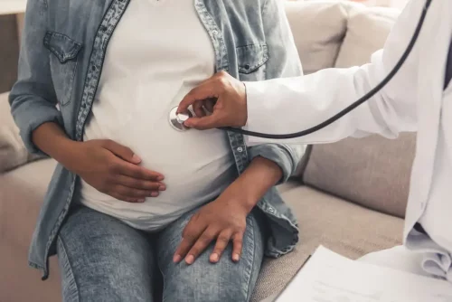 A pregnant black woman receiving medical care (VGstockstudio/Shutterstock)