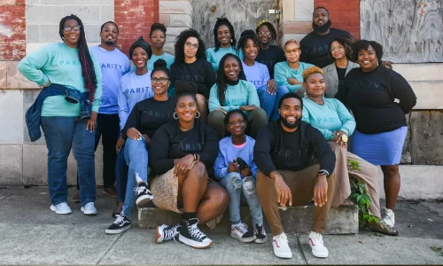 Bree Jones with members of her buyers' collective in front of one of Baltimore's rowhouses. (Photo courtesy of Parity Homes)