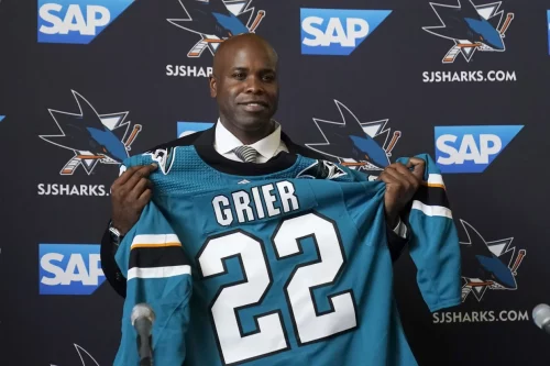 Mike Grier holds a Jersey as he is introduced as the San Jose Sharks' new GM on July 5, 2022. (Jeff Chiu / AP)