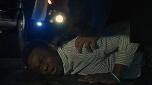 A scene from the movie "Emergency" depicting a Black man held down at gunpoint. (Amazon Studios)