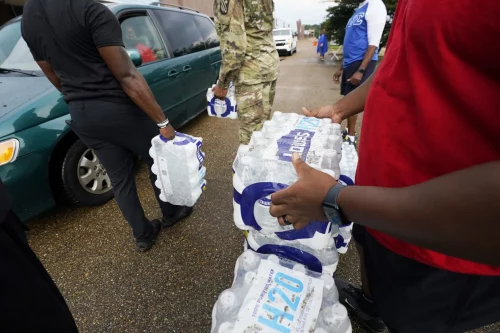 Volunteers distribute cases of water at a community drive-thru water distribution site in Jackson, Miss., on Sept. 7. (Rogelio V. Solis / AP file)