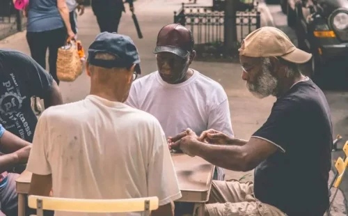 Several older Black men sit around a table (Credit: Craig Adderley / Pexels)