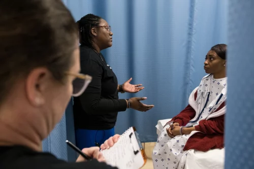 Beth Andrews-Arce, left, and Sharita Godwin, center, role play through an examination during sexual assault nurse examiner training at Fayetteville State University. (Cornell Watson for NBC News)