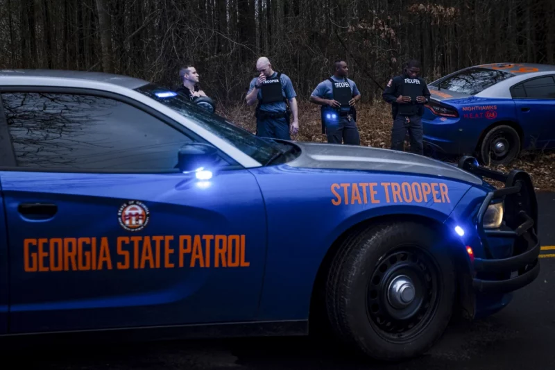 Georgia State Patrol troopers guard construction equipment used in razing eco-activists' squats in the South River Forest near Atlanta