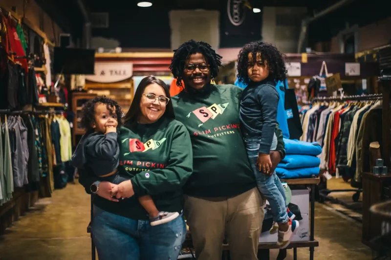 Jahmicah Dawes, right, his wife, Heather, and their children inside Slim Pickins Outfitters.