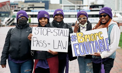 Activists hold up signs at a rally for housing justice in Baltimore, Maryland. (BRIAN O'DOHERTY/YES! MEDIA)
