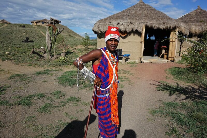 Maasai of Tanzania in traditional clothing celebrating Christmas and wearing a Santa hat