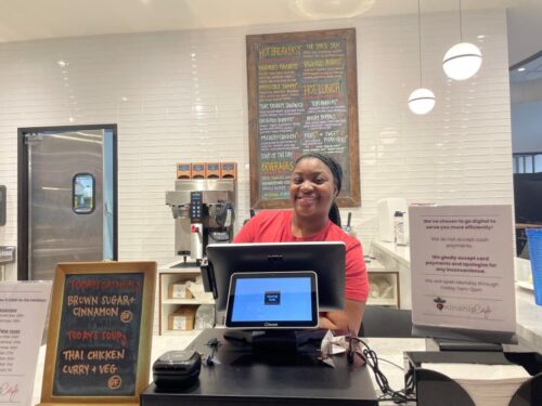 Manager Shania Hutchins stands behind the register at Milwaukee’s Kinship Cafe on Dec. 19, 2024. (Nick Rommel/WPR)