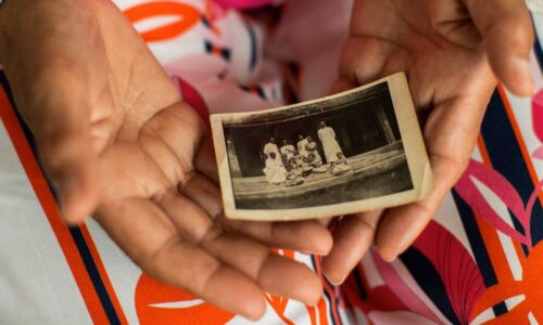 Monique Bitu Bingi, one of the plaintiffs in the case, holds holds a photo of herself as a young girl before she was forcibly removed from her parents. (Francisco Seco/AP)