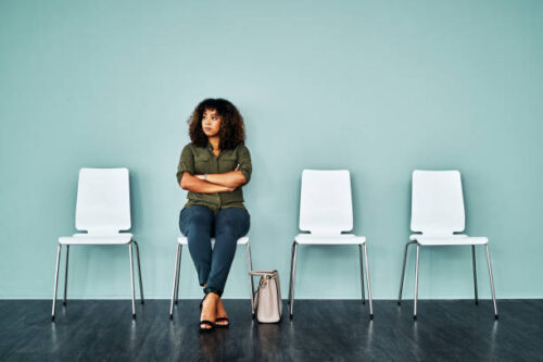 Studio shot of a young businesswoman waiting in line against a blue background Studio shot of a young businesswoman waiting in line against a blue background
