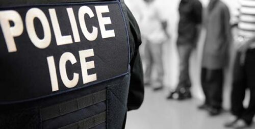 ICE_Immigration_Raid_Scene US ICE label on officer's jacket