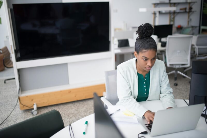 Black woman in blazer working at laptop