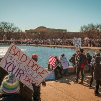 Protestors with signs near the U.S. Capitol Reflecting Pool