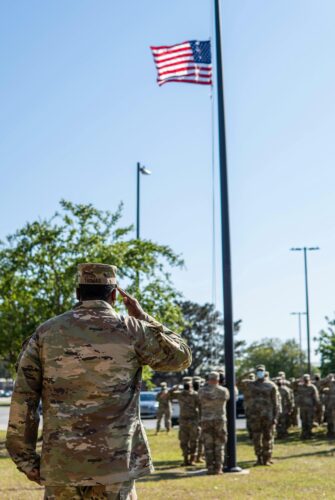 Soldier's saluting the American flag.