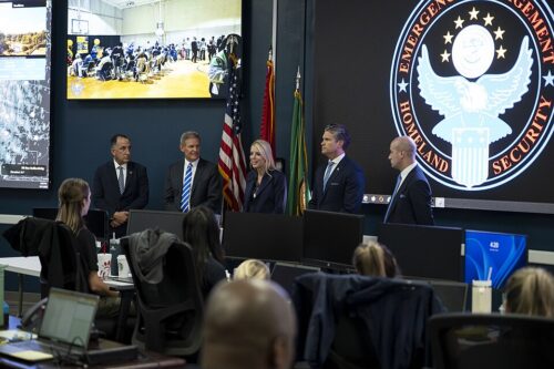 Pete Hegseth, Pam bondi, and Stephhen Miller in front of a room of people
