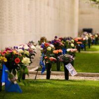 Flowers on the ground near a memorial in the Netherlands American Cemetery